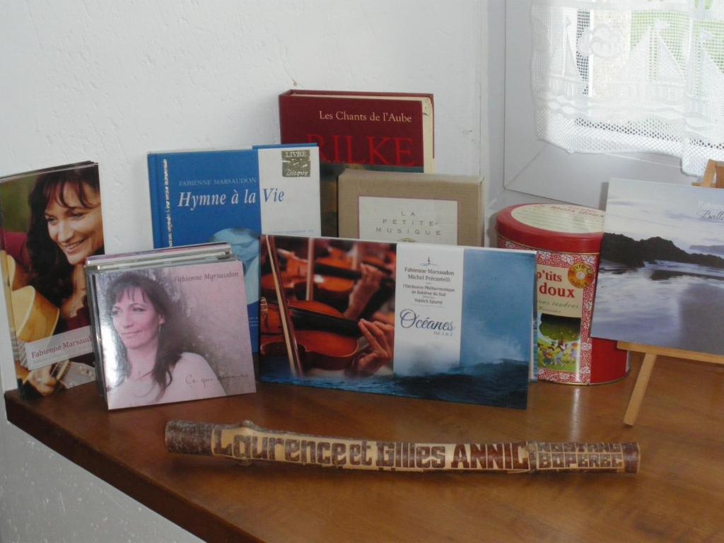 a wooden table with books and pictures on it at Ferme de Bopérec in Nostang