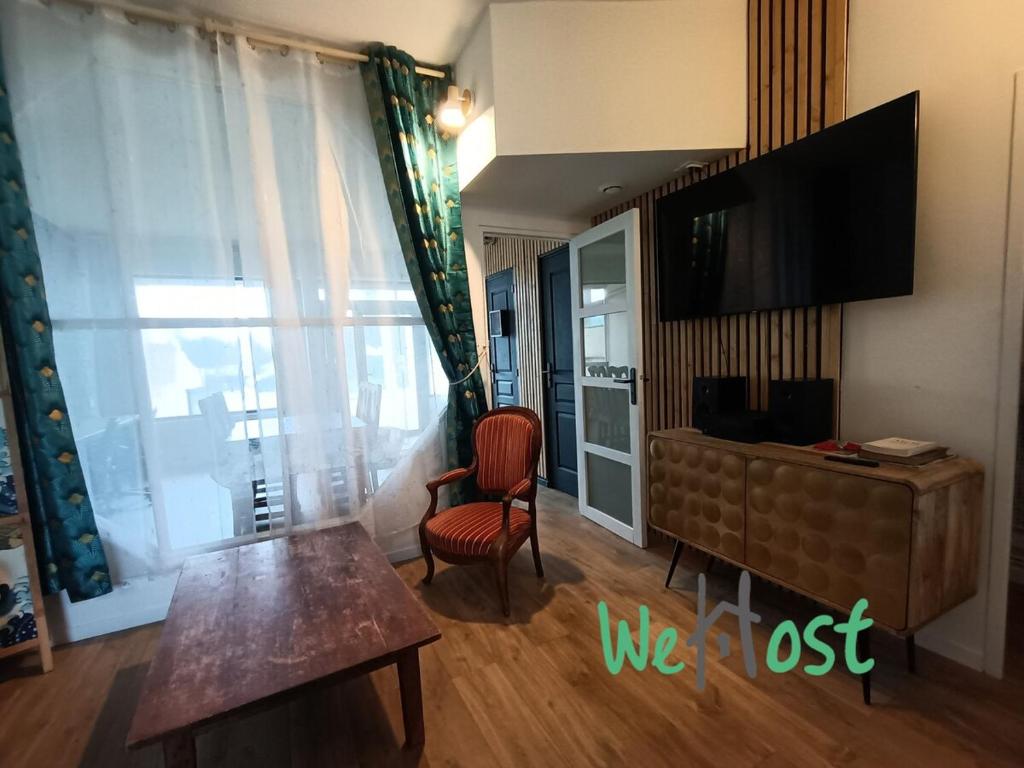 - un salon avec une télévision, une chaise et une table dans l'établissement Foc - Original loft Beach - Port, à La Rochelle