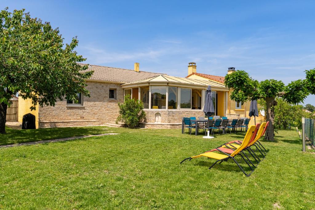 une maison avec une cour dotée d'une pelouse jaune dans l'établissement Gîte Refuge des Amis, à La Verrie