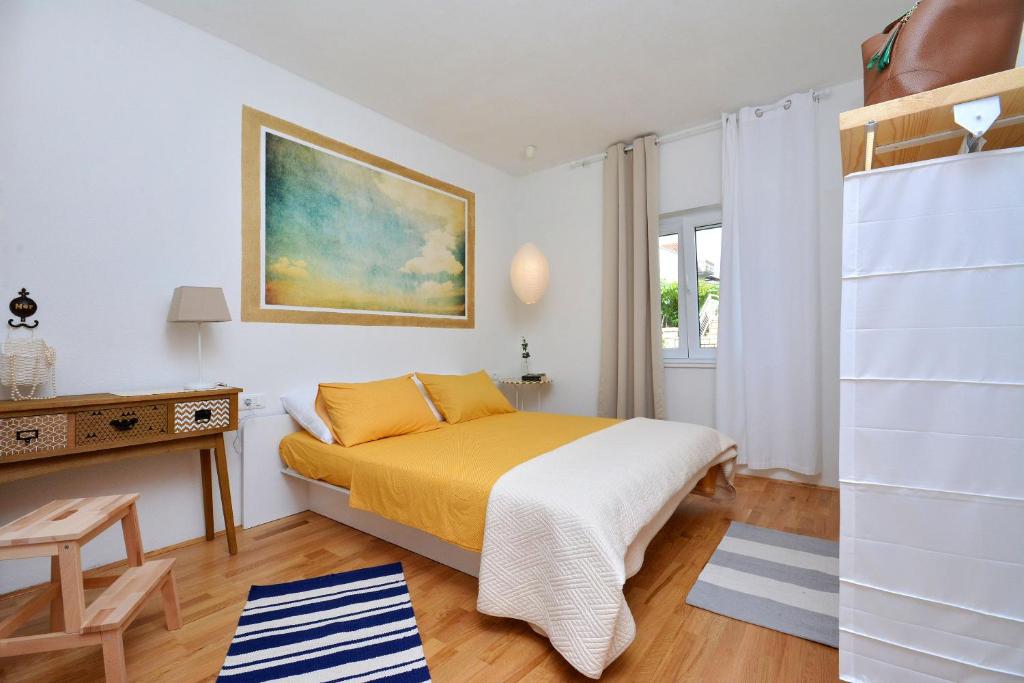 a small bedroom with a bed and a desk at Apartment Pepica in Postira