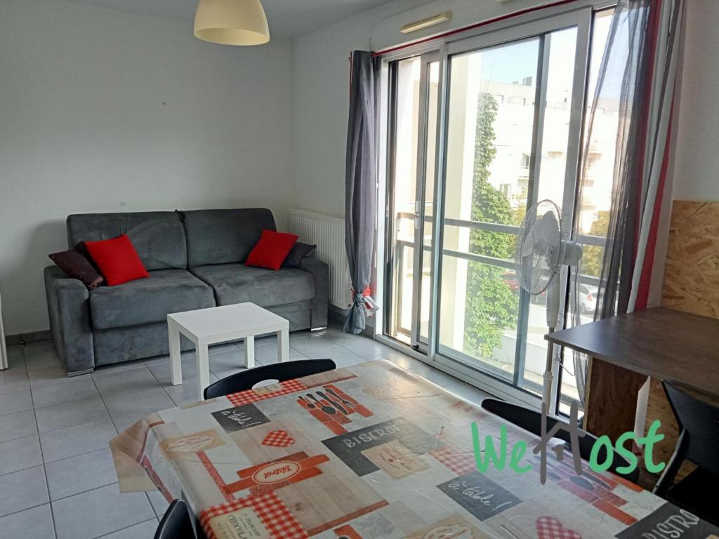 un salon avec un canapé et une table dans l'établissement Flora - Studio Proche gare Parking, à La Rochelle