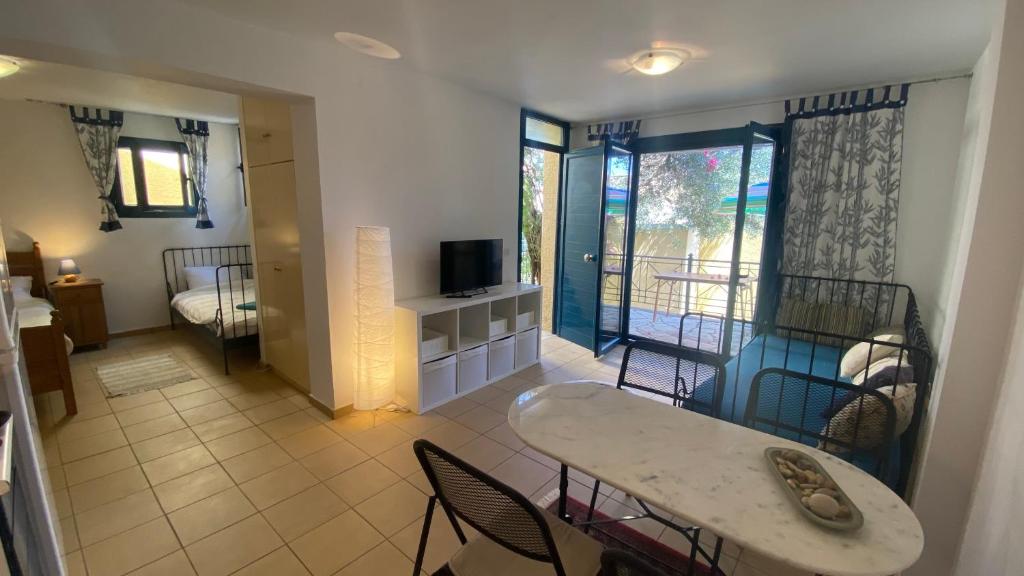 a living room with a table and chairs and a television at Barbati Olive in Barbati