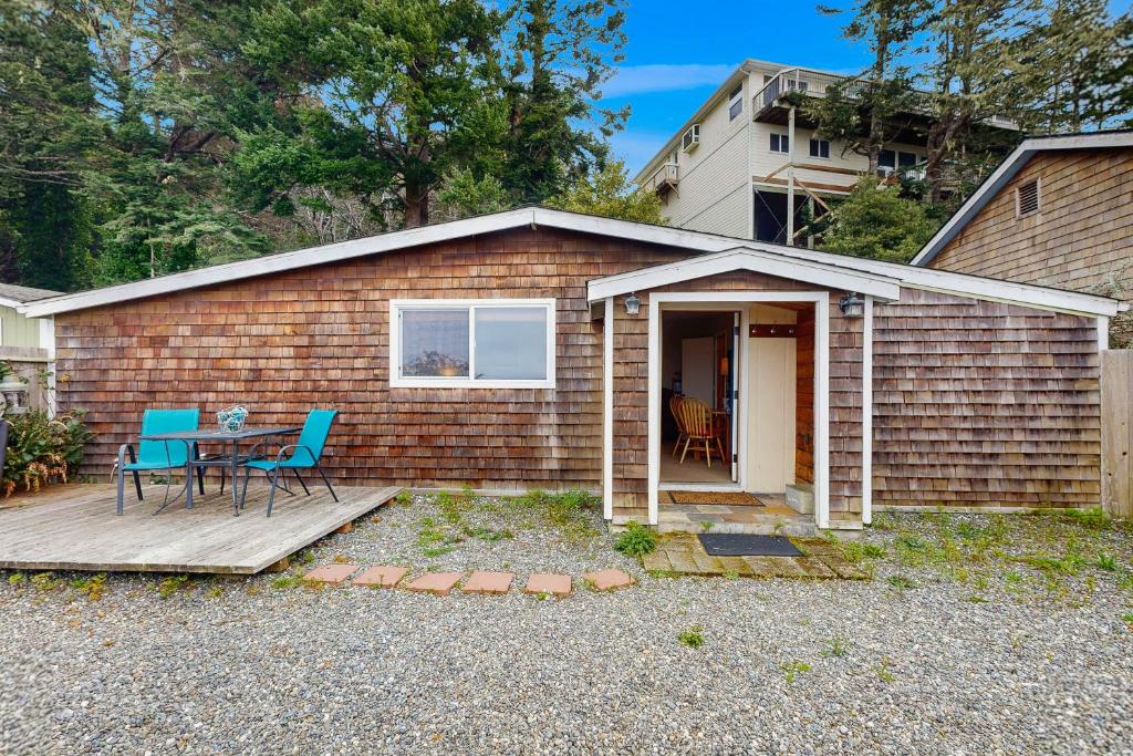 a small brick house with a table and chairs at Harbor View Studio Cottage in Gold Beach