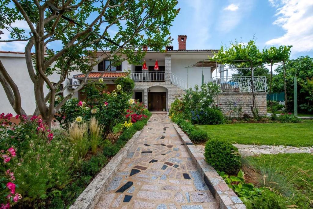 una casa con un camino de jardín delante de ella en Vinez, en Labin