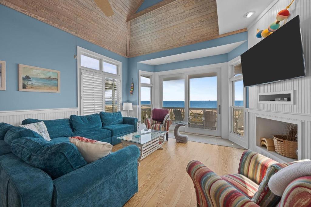 a living room with a blue couch and a fireplace at Dolphin Dreams home in Atlantic Beach
