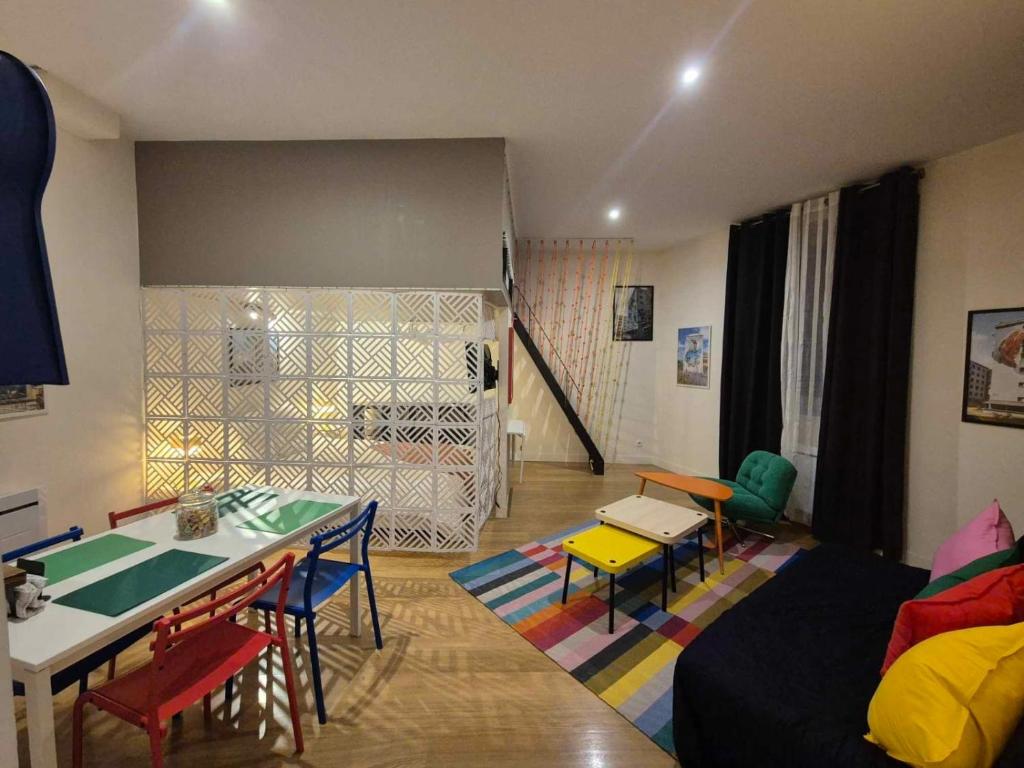 un salon avec un canapé, une table et des chaises dans l'établissement The Artist - Hypercentre, à Grenoble