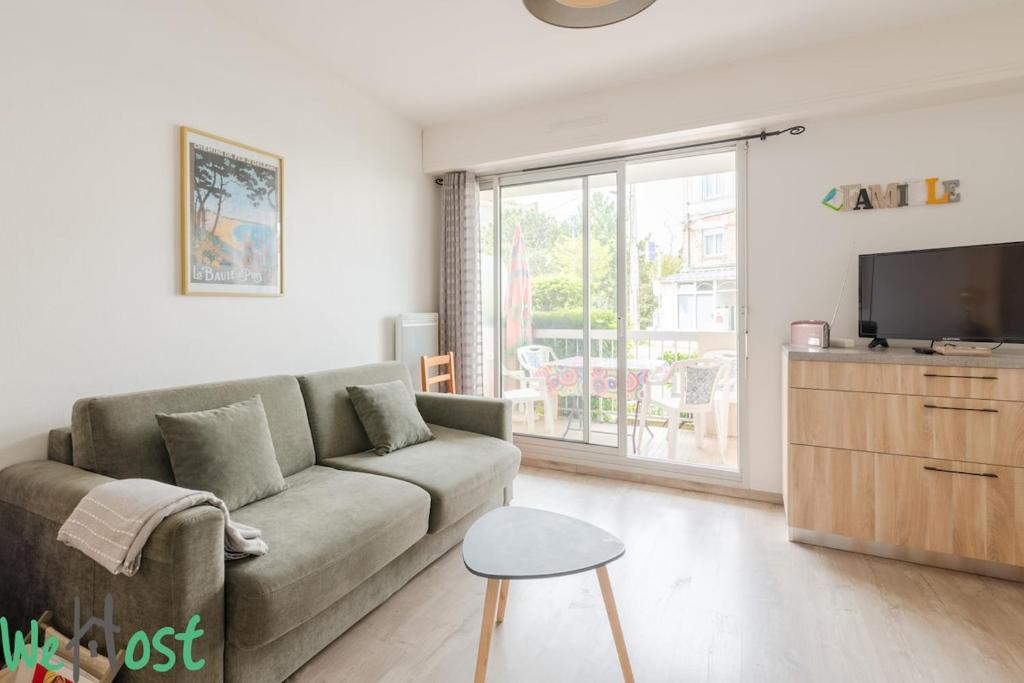 un salon avec un canapé et une télévision dans l'établissement Bouchardat - near sea - 2p, à La Baule