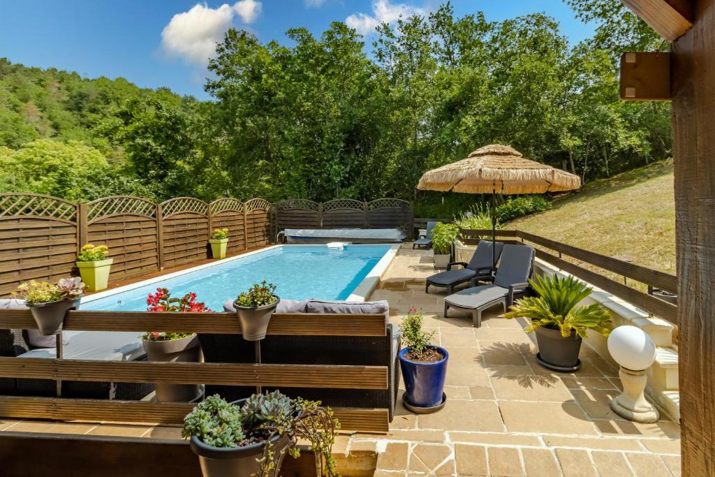 une arrière-cour avec une piscine dotée d'un banc et de plantes dans l'établissement Gite Les Gaps en Périgord noir, à Aubas