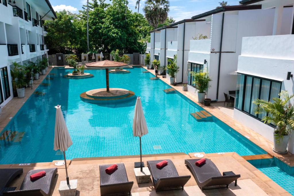 an overhead view of a swimming pool with chairs and umbrellas at Sai Naam Lanta - Apartments & Townhouses in Ko Lanta