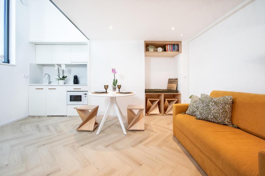 ein Wohnzimmer mit Sofa und Tisch in der Unterkunft T0 do Carril, Aveiro in Aveiro