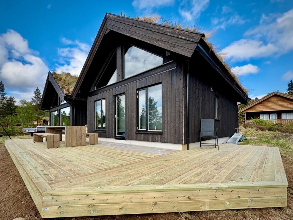 a black house with a wooden deck in front of it at Brand new cabin at Hovden cross-country skiing in Hovden