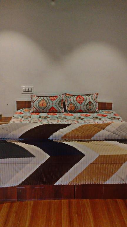 a bedroom with a bed with a quilt on it at River side cafe guest cottage in Shamshi