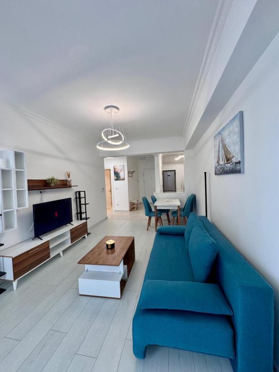a living room with a blue couch and a table at Romantic Solid Lamera Residence in Mamaia