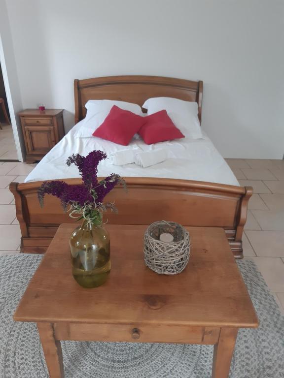 un lit avec des oreillers rouges et un vase sur une table dans l'établissement Villa Marie, à Draguignan
