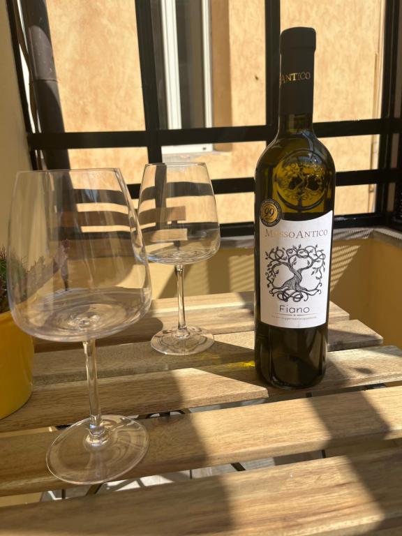 eine Flasche Wein und zwei Gläser auf einem Tisch in der Unterkunft Nas's House in Ronciglione