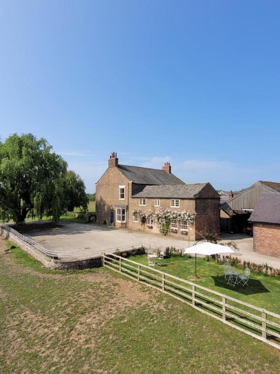 a large house with a fence and a yard at Burton Grange Farmhouse Bed and Breakfast in Boroughbridge