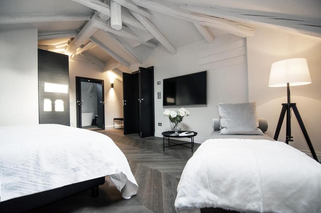 a white bedroom with two beds and a lamp at Madame Marconi XVII in Mira