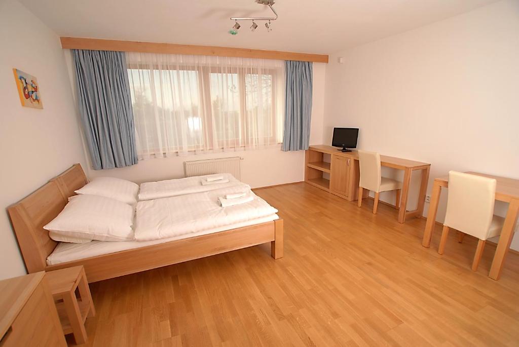 Habitación con cama, mesa y escritorio. en Rezidence & Wellness Blatov, en Praga