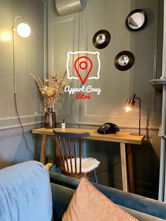 une chambre avec une table et un panneau sur le mur dans l'établissement AppartCosy 08 Charme et Authenticité, à Vitré