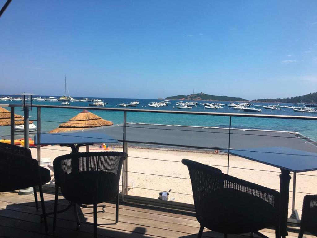 - une terrasse avec des chaises et un parasol, ainsi qu'une plage dans l'établissement La corse les pieds dans l'eau, à Pinarellu