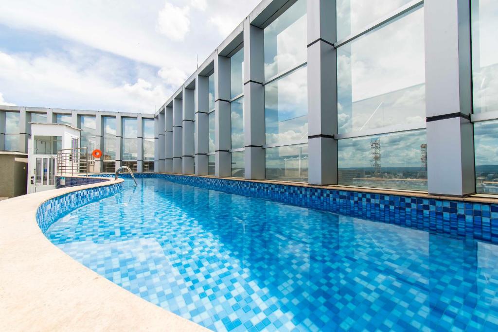einen Pool in einem Gebäude mit großen Fenstern in der Unterkunft Fusion Hotel em Brasília 15451 in Brasilia
