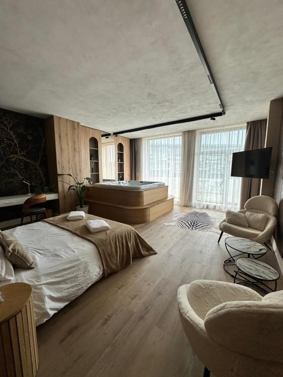 a bedroom with a large bed and a large window at Alpine Oasis - Silver Mountain in Poiana Brasov