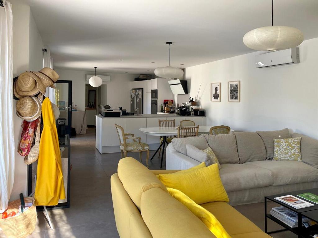 a living room with a couch and a kitchen at Maison de charme avec piscine, escapade, détente in La Rochelle