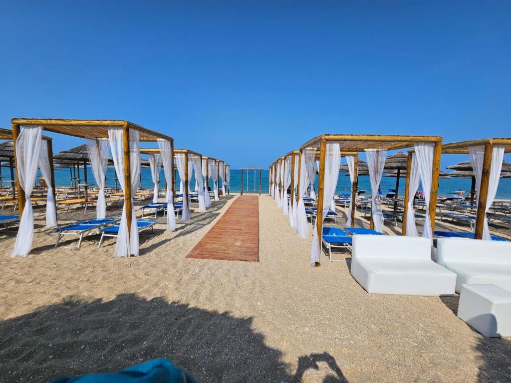 a row of chairs and umbrellas on the beach at Appartamento Estivo in Porto Potenza Picena