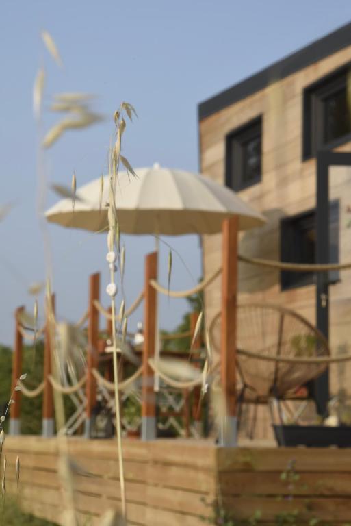 - un groupe de chaises, un parasol et une table dans l'établissement La Tiny House des Vignes du Château de Vauclaire, à Meyrargues