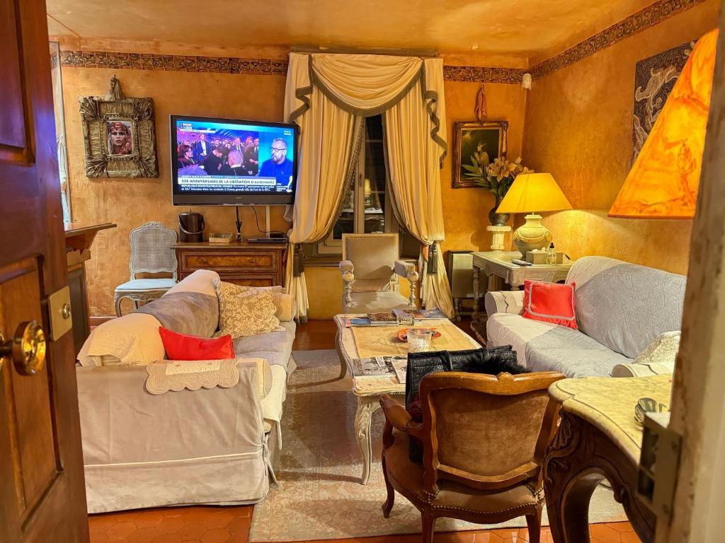 un salon avec des canapés et une télévision dans l'établissement Appartement de luxe au cœur de Saint-Tropez, à Saint-Tropez