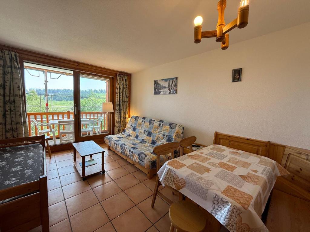 un salon avec un lit et un canapé dans l'établissement Les Saisies: Studio cabine 5 pers avec balcon, TV et casier à skis - FR-1-293-130, aux Saisies