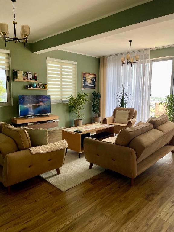 a living room with two couches and a tv at Glass house in Ulcinj