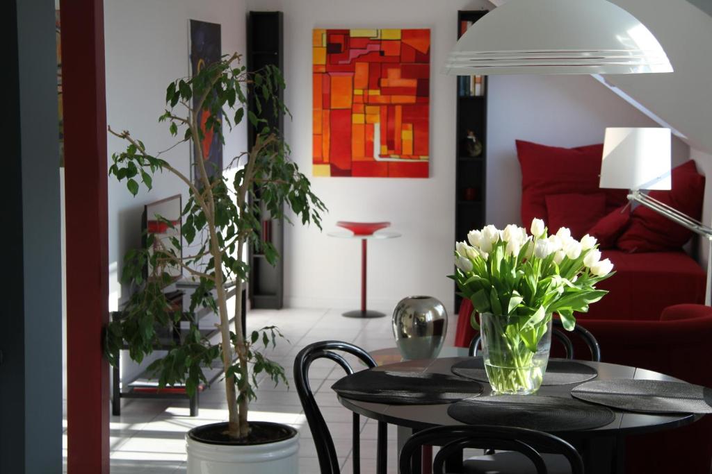 uma sala de estar com uma mesa com flores em Köln-Kerpen Boutique-Ferienwohnungen Angela & Maurizio em Kerpen