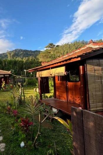 a small house with a porch in a field at Yucan Ecostay Bedugul in Bedugul