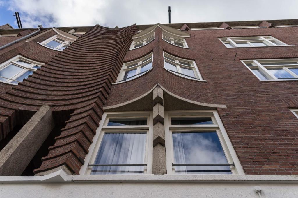 un edificio alto de ladrillo con ventanas y techo en B&B House No 7 en Ámsterdam