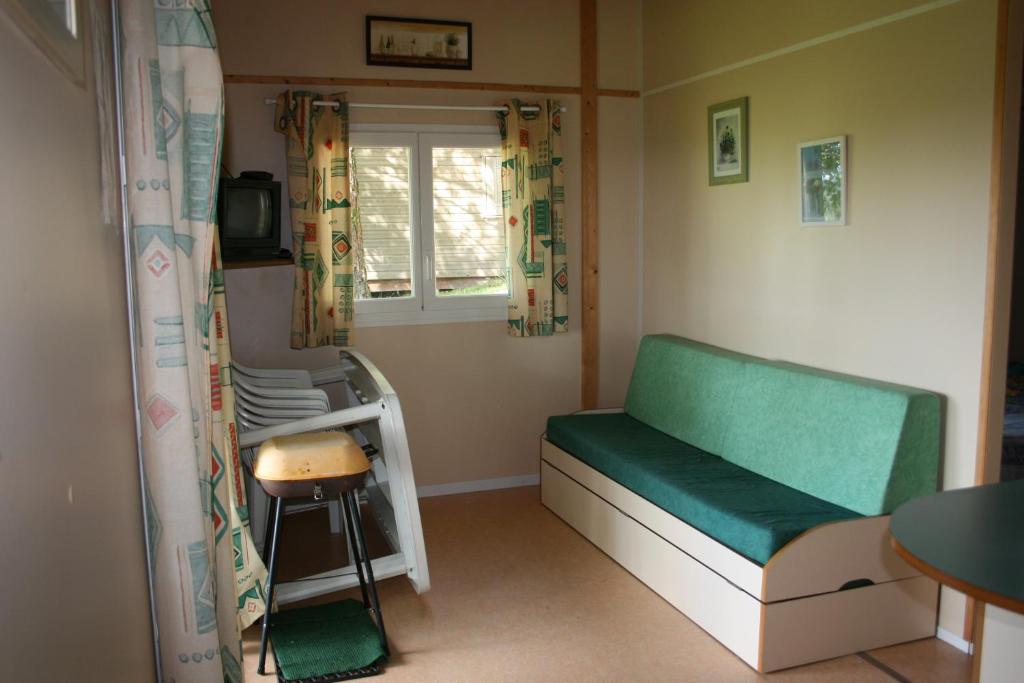 a small room with a bed and a window at La Ptite Ferme de Caro in Meyrignac-lʼÉglise