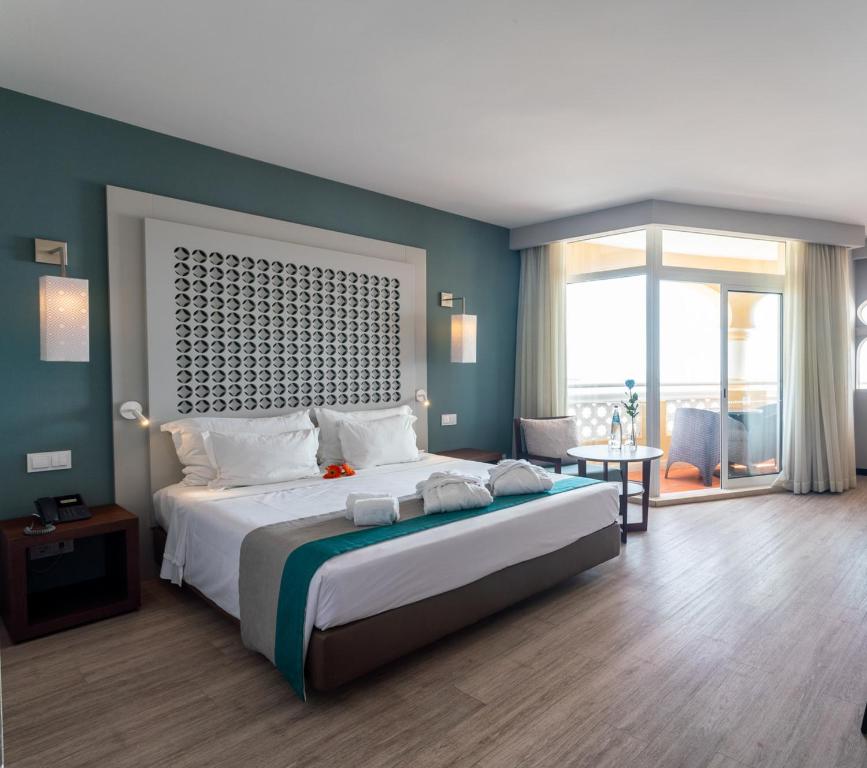 a bedroom with a large bed and a large window at AP Oriental Beach - Adults Friendly in Portimão