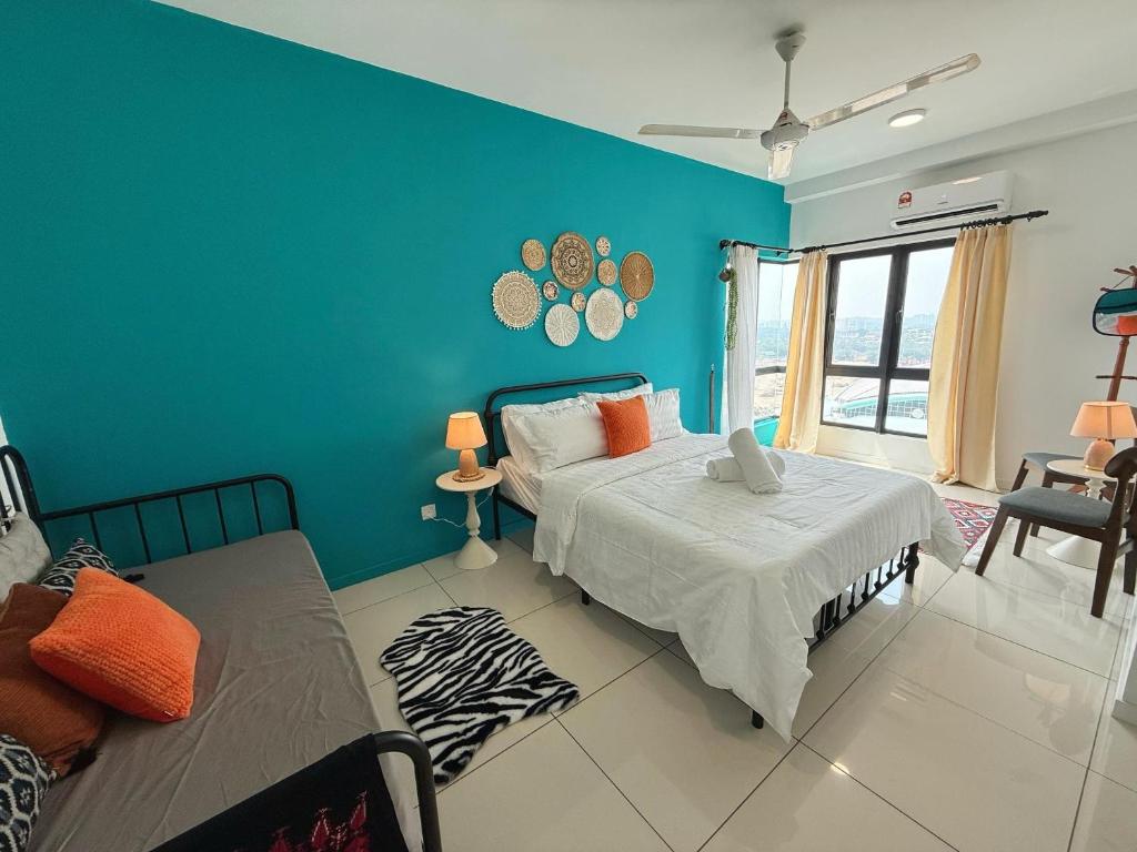 a bedroom with a bed and a blue wall at Emira Residence Seksyen 13 Shah Alam by Alpha LaVista in Shah Alam