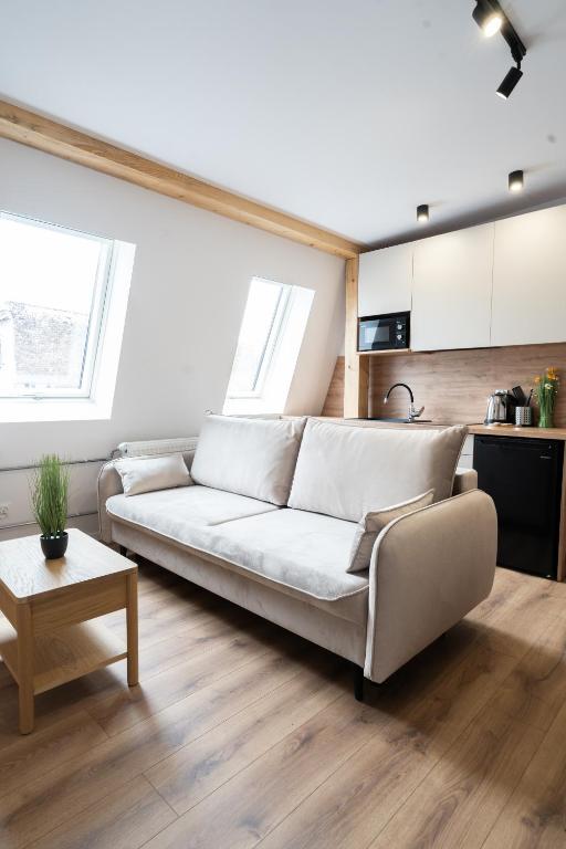 a living room with a white couch and a table at HostLoop Apartments - Świętego Pawła 10 in Katowice