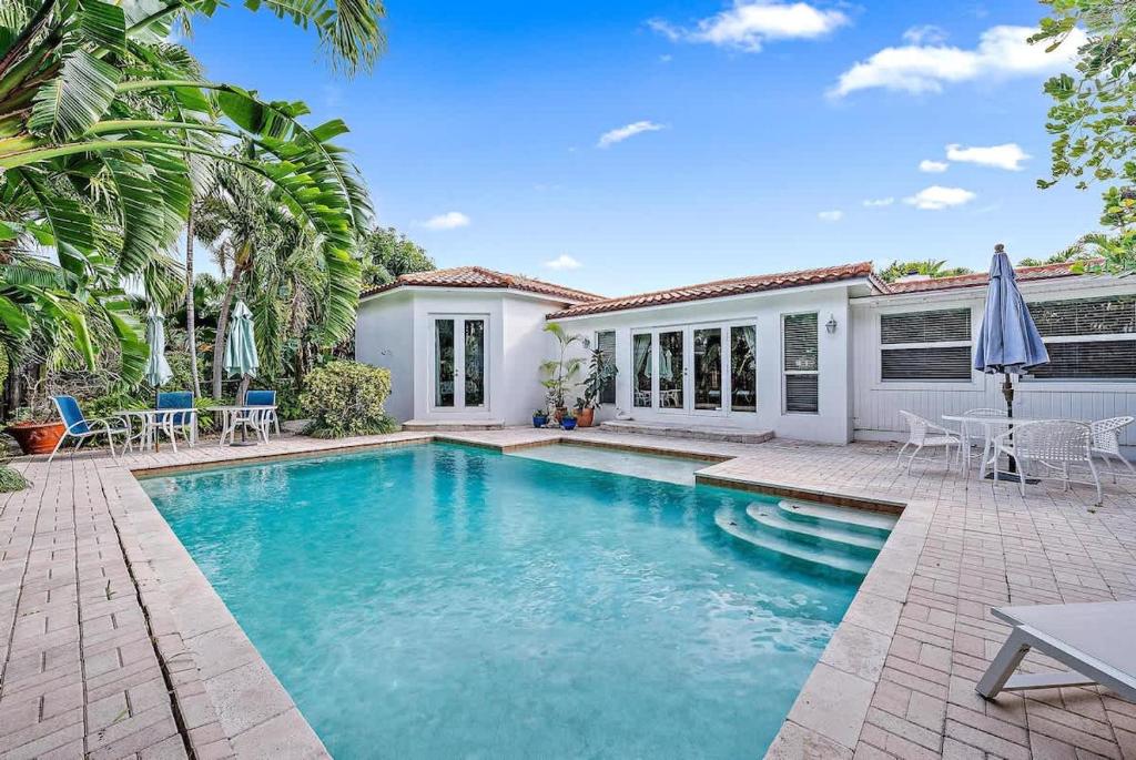 a swimming pool in front of a house at Casa Balsinde - Delight in a Private Pool in the Southern End of West Palm in West Palm Beach