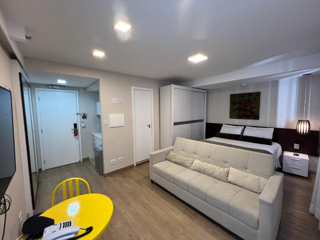 a living room with a couch and a bed at Hotel Borges Lagoa Pq Ibirapuera 1116 in São Paulo