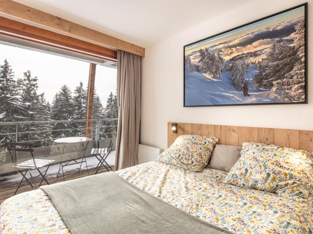 a bedroom with a bed and a balcony with a view at Très bel appartement exposition sud classé 3 étoiles in Chamrousse