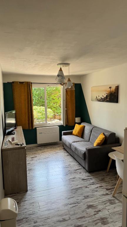 a living room with a couch and a table at Studio Cosy - Mandelieu in Mandelieu-La Napoule