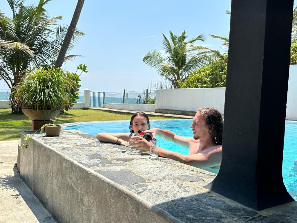 a woman taking a picture of a child in a swimming pool at Tuktuk Cabanas in Negombo