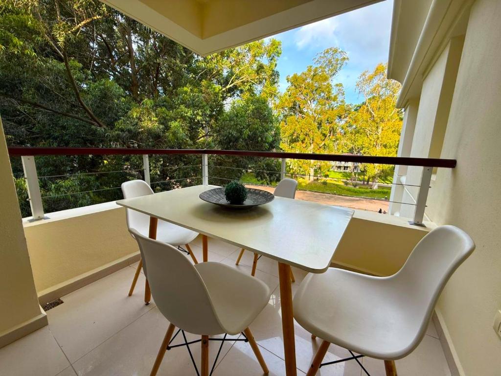 a white table and chairs on a balcony with a window at Depto con terraza en Green Park, Punta del Este in Punta del Este