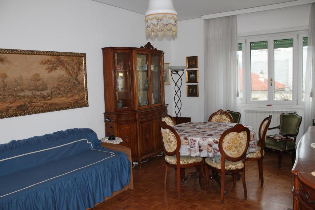 a bedroom with a bed and a table and chairs at Coroneo33 - Spazioso per famiglie - NaonBnB in Trieste