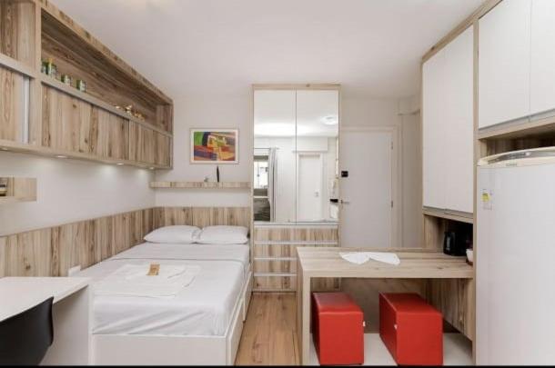 a room with two beds and red chairs in it at Loft estiloso no centro, perto de tudo!!!! in Curitiba