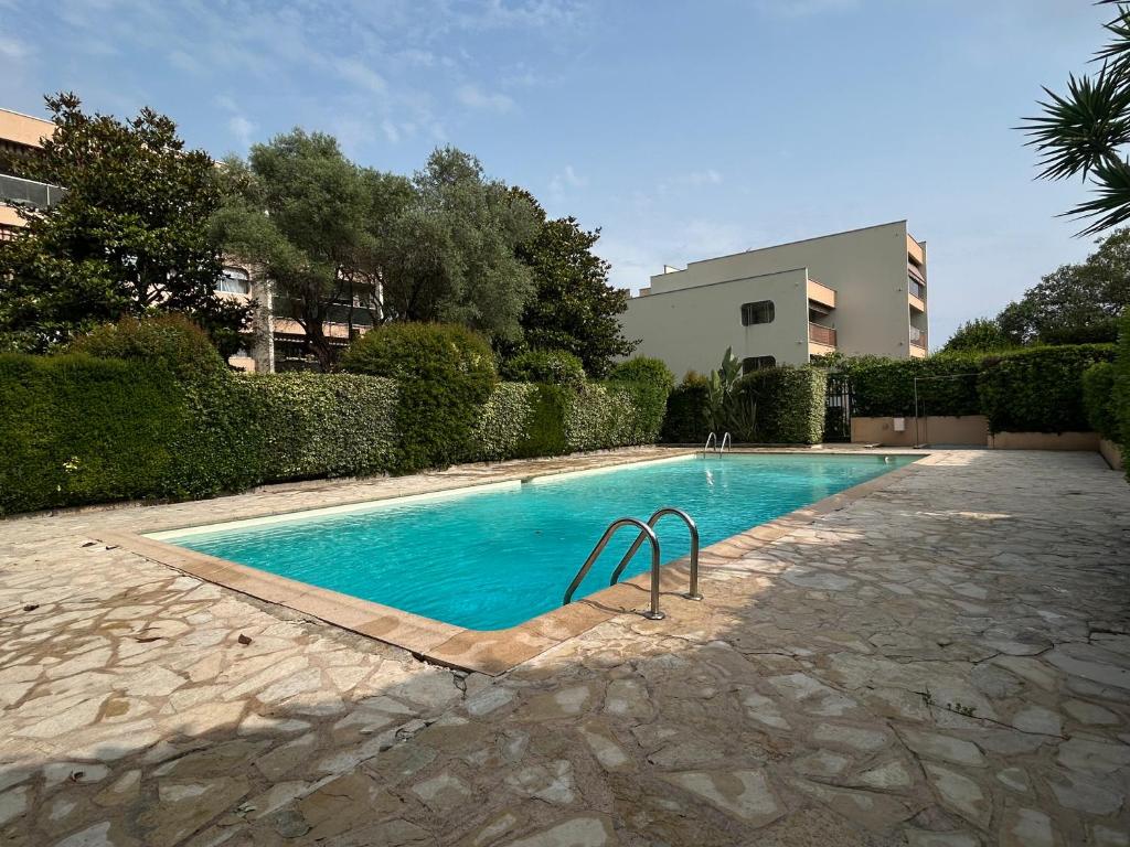 - une piscine dans une cour à côté d'un bâtiment dans l'établissement Magnifique Studio dans résidence avec Piscine, à Antibes
