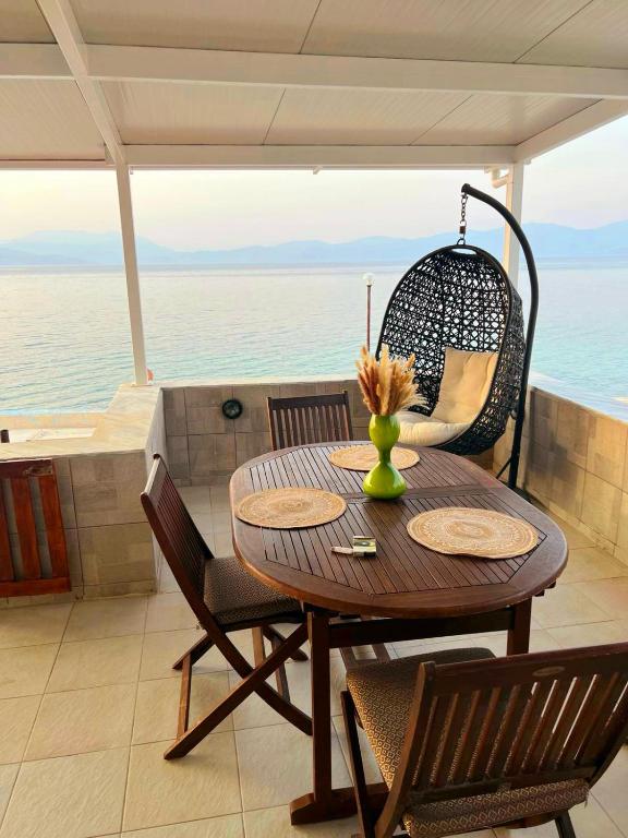 a table and chairs with a view of the ocean at Filis mare apartment in Xylokastro