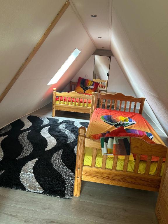 a attic bedroom with two beds and a rug at Elli's Küstenherz in Kiel